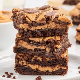 A close-up of a stack of chocolate peanut butter brownies with creamy peanut butter swirls, highlighting the gooey chocolate layers and decadent texture.