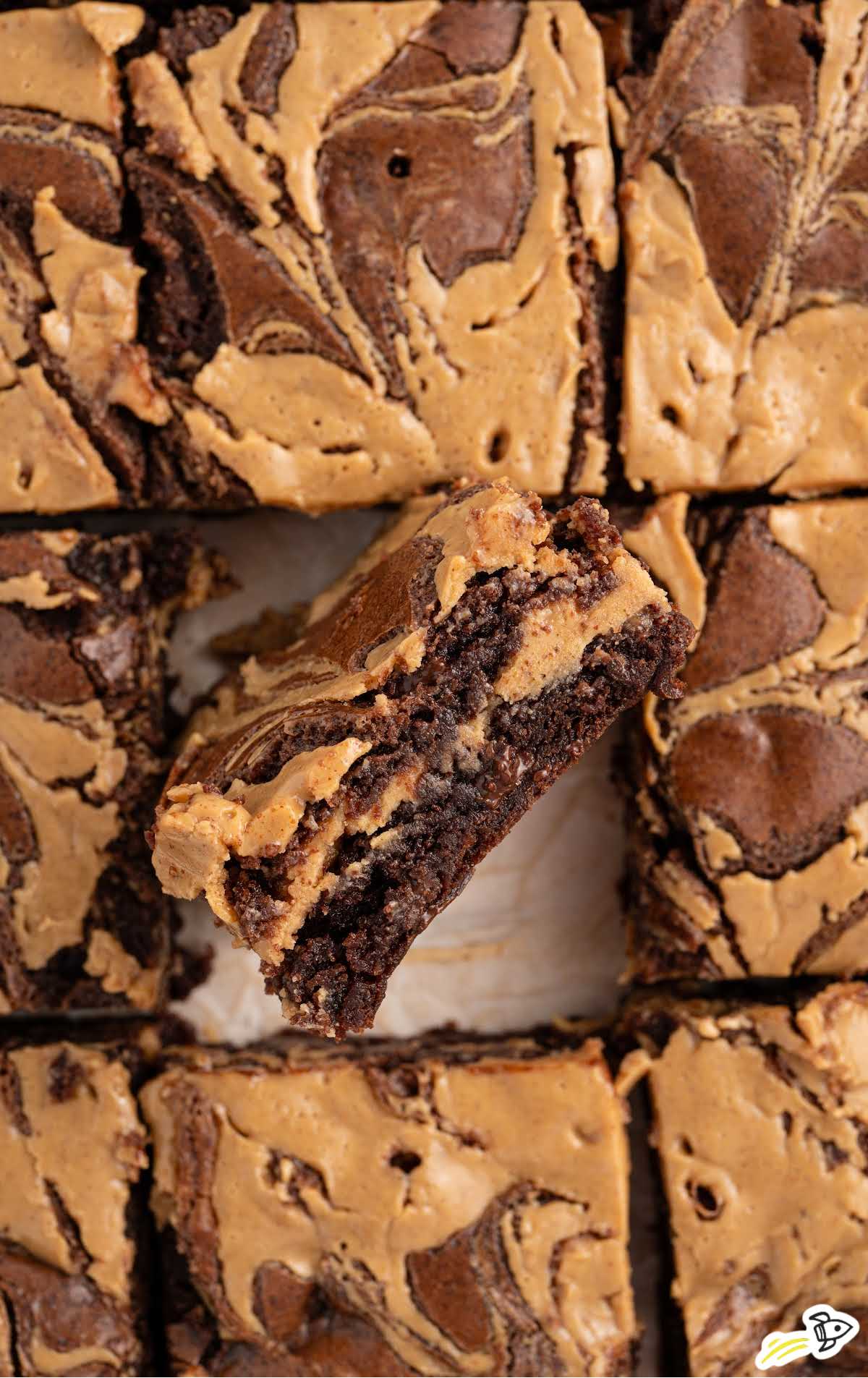 A top-down view of sliced chocolate peanut butter brownies, featuring the creamy peanut butter swirl designs on each piece.