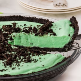 A Grasshopper Pie in a glass pie plate with a slice lifted out.