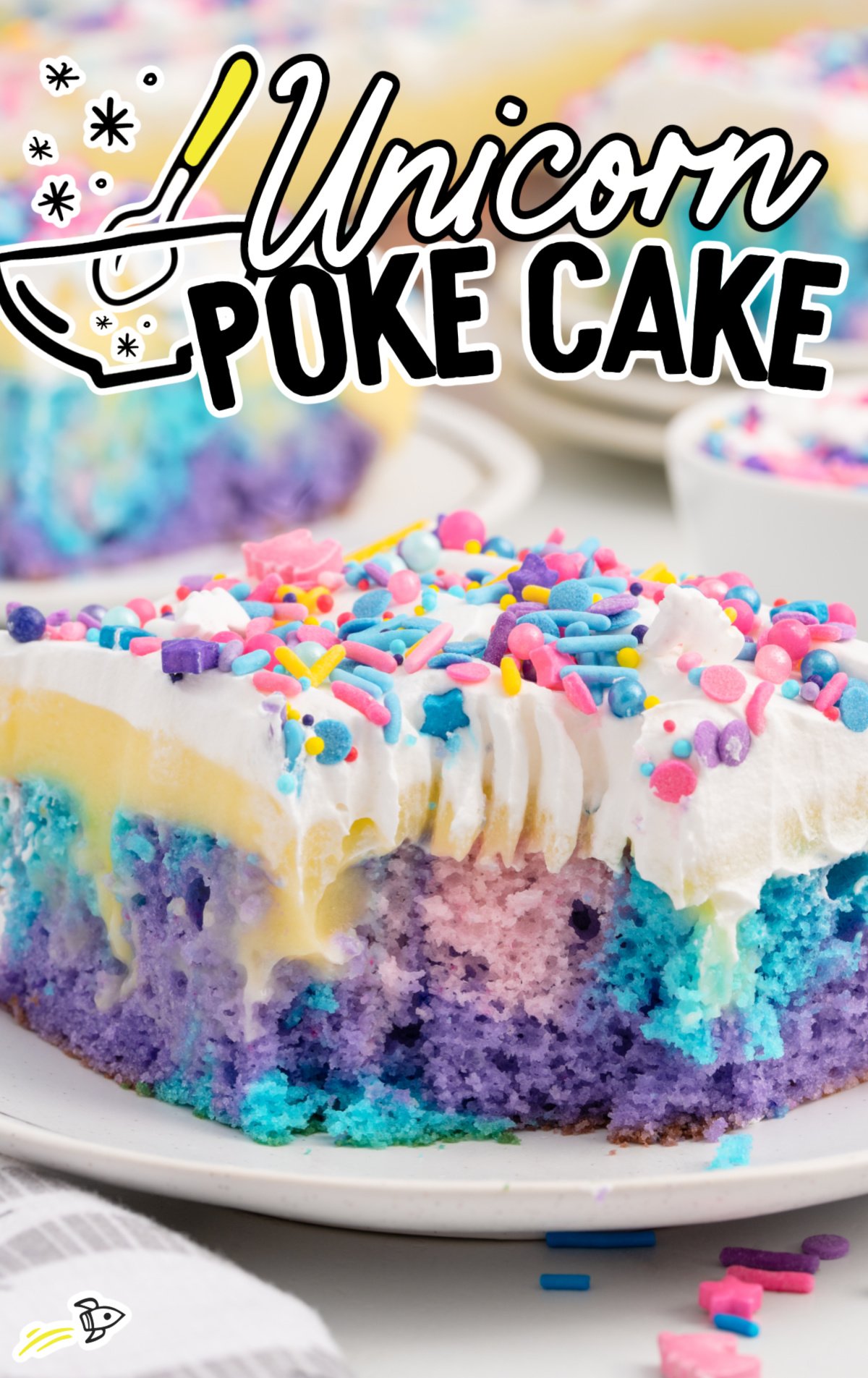 A piece of unicorn poke cake on a white plate with a bite out of it. 