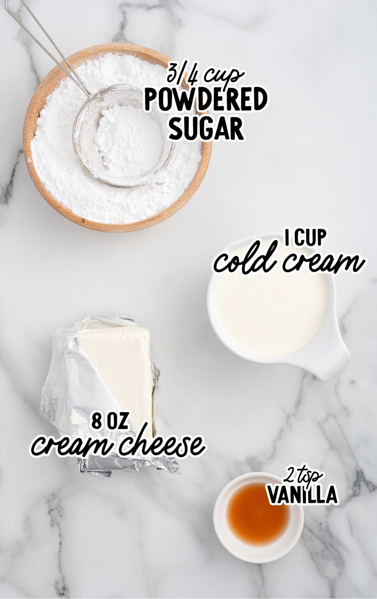 Ingredients for cheesecake dip, including powdered sugar, cream cheese, heavy cream, and vanilla extract, laid out on a marble surface.