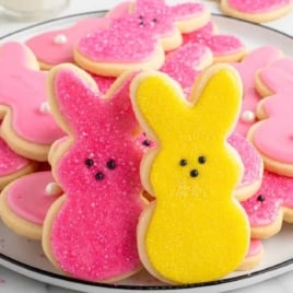 Decorated Easter bunny cookies with pink and yellow icing displayed on a platter for Easter dessert