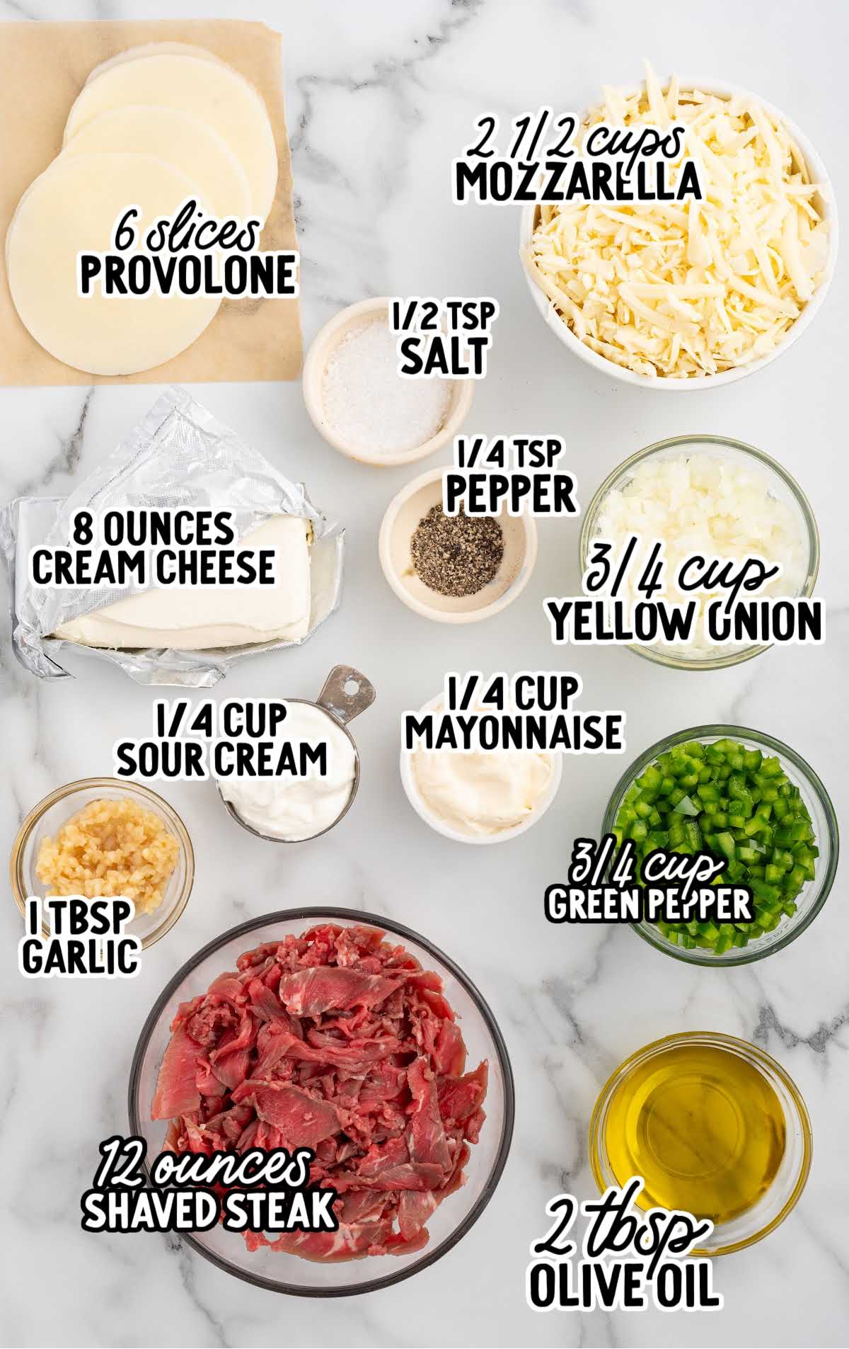 An organized display of Philly cheesesteak dip ingredients, including provolone cheese slices, mozzarella, cream cheese, shaved steak, and chopped vegetables.