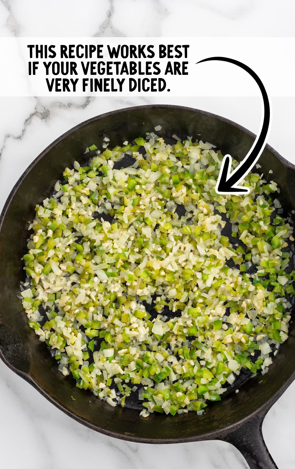 A cast iron skillet with finely diced green bell peppers, onions, and garlic being sautéed. A text overlay emphasizes that the recipe works best when the vegetables are very finely diced
