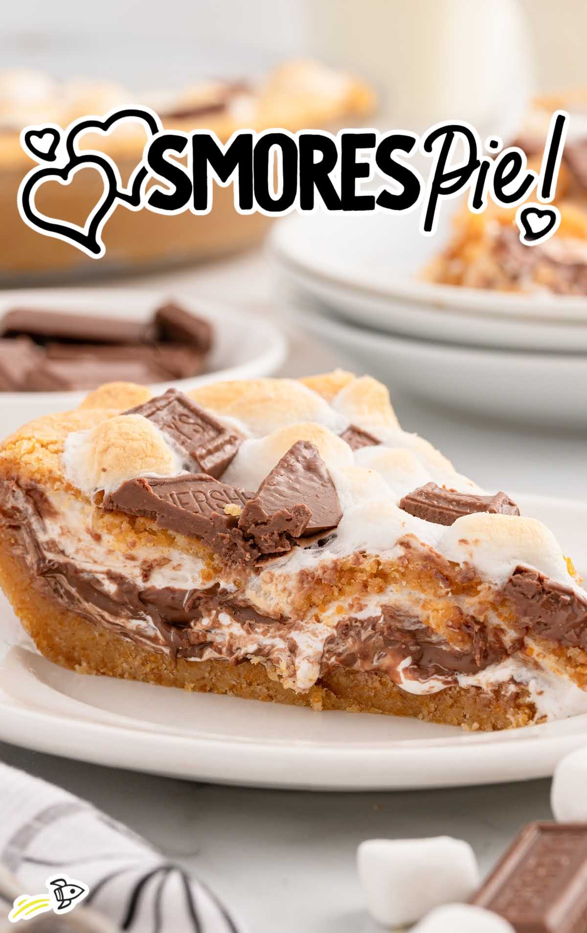 A single slice of s'mores pie on a plate, showcasing melted marshmallow and chocolate layers with a graham cracker crust.