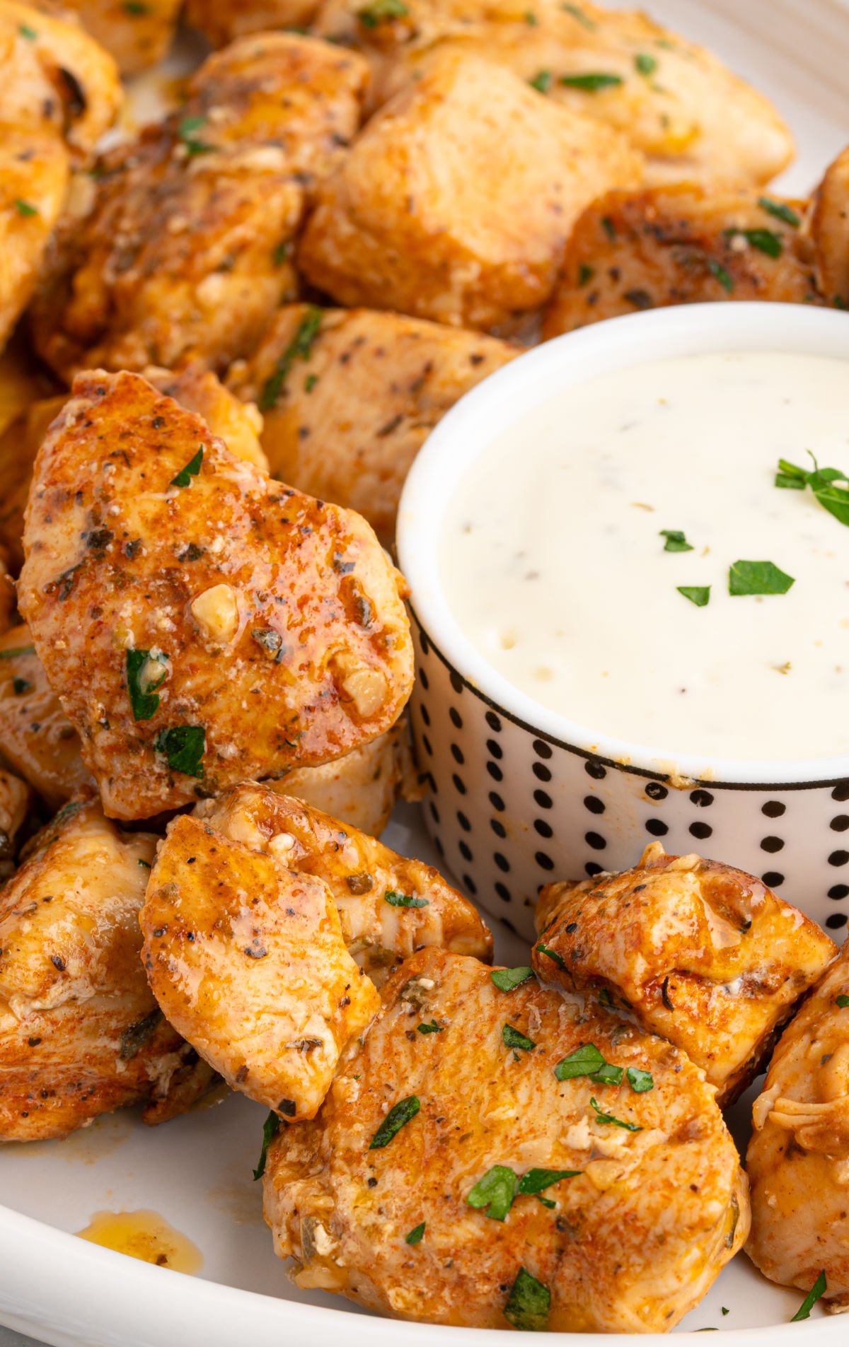 Garlic butter chicken bites served with dipping sauce on a plate