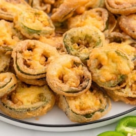 Close-up of golden brown jalapeño bottle caps on a white plate, ready to serve