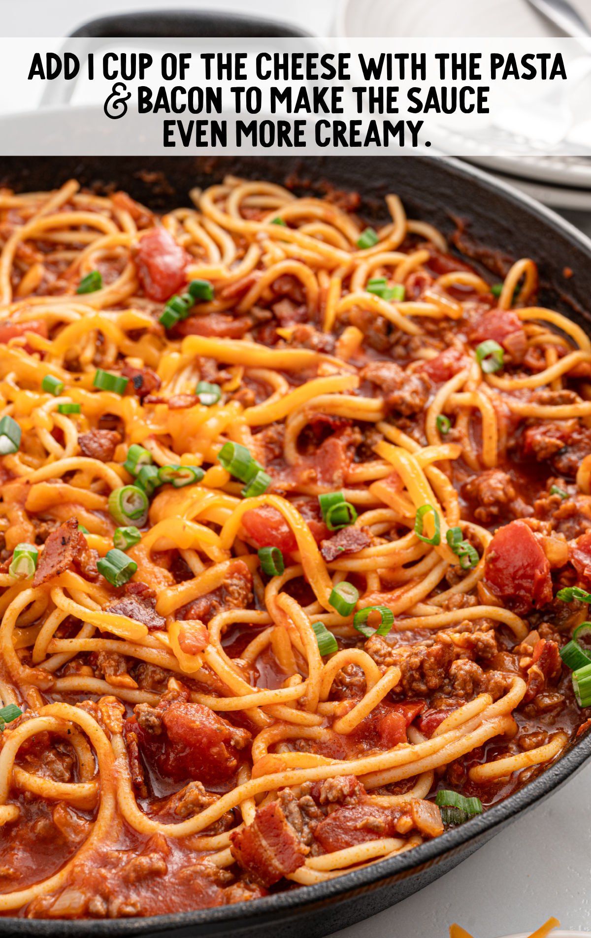 spaghetti topped with cheese in a skillet