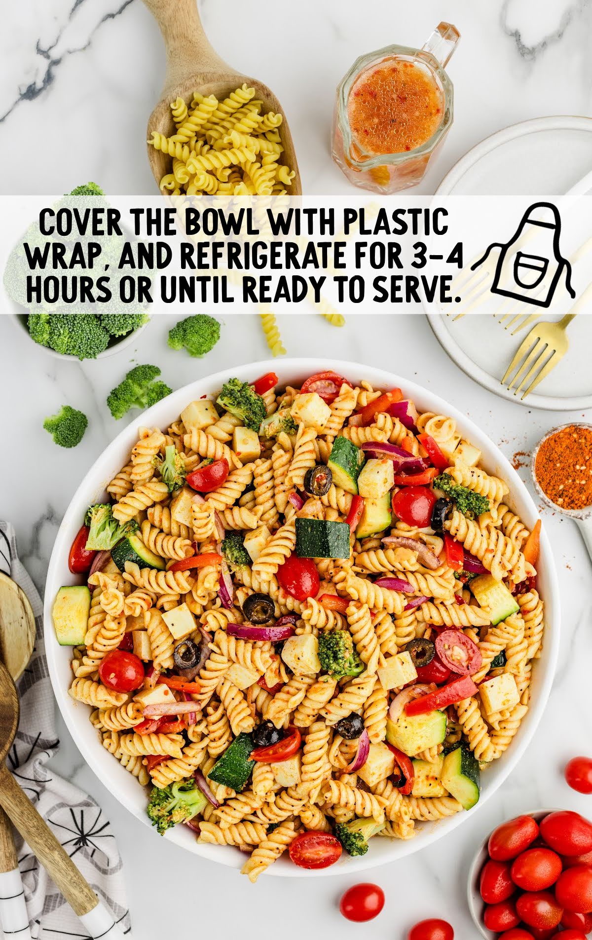 Pasta salad in a bowl with plastic wrap tip overlay suggesting refrigeration for 3–4 hours before serving