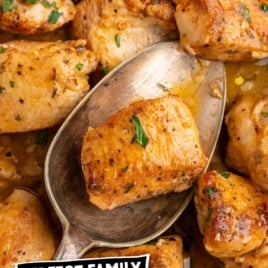 Spoon lifting garlic butter chicken bite over mashed potatoes and green beans.