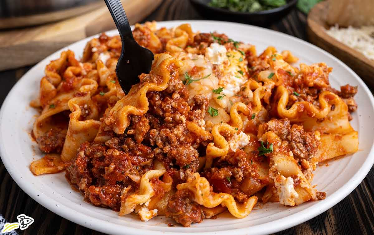 Serving of skillet lasagna on plate showing noodles, beef sauce, and melted cheese