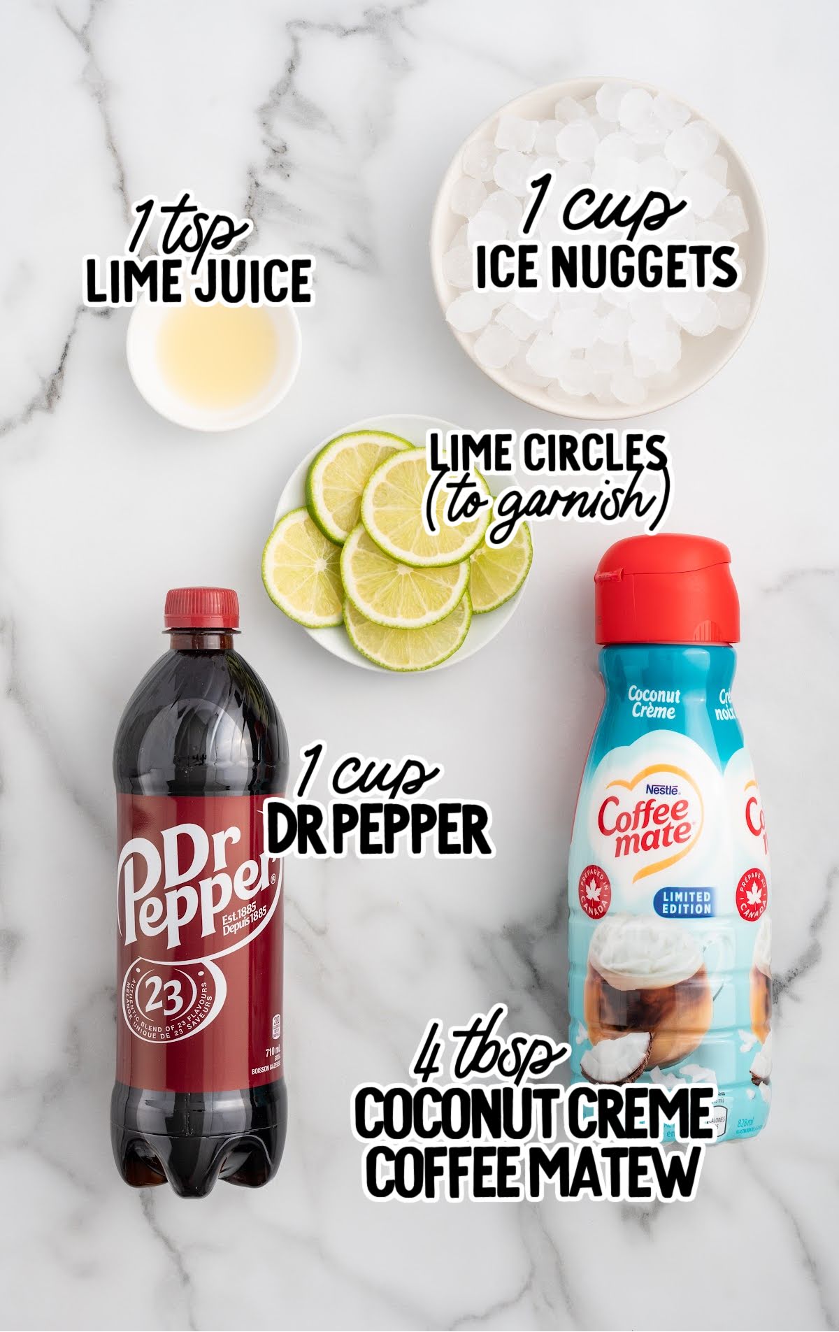 Flat lay of Dirty Dr Pepper ingredients including Dr Pepper, coconut creme coffee creamer, lime juice, ice nuggets, and lime slices for garnish.