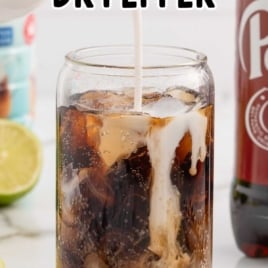 Glass of Dirty Dr Pepper being poured with creamer, labeled as a simple and fun mocktail recipe.