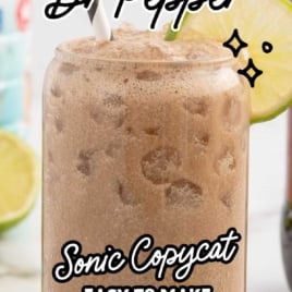 Close-up of frothy Dirty Dr Pepper in a glass garnished with lime and text highlighting it as a Sonic copycat recipe.
