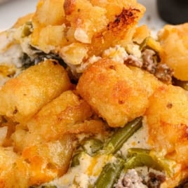 Plate of hamburger tater tot casserole with text overlay: “Hamburger Tater Tot Casserole – With Green Beans & Tons of Cheese!”