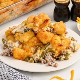 Flat lay of labeled ingredients for hamburger tater tot casserole including tater tots, cheddar cheese, and sour cream.