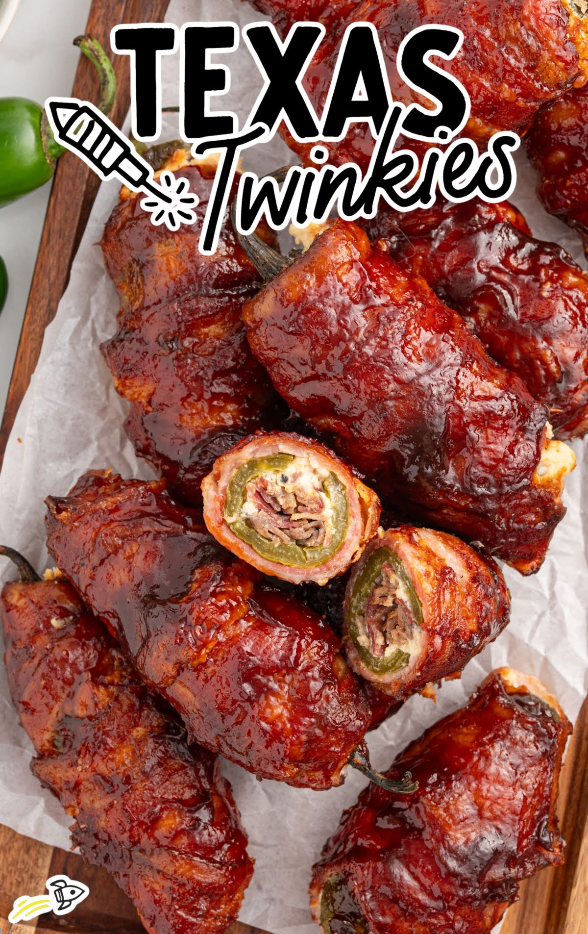 Texas Twinkies stacked and sliced to reveal the cheesy brisket-stuffed jalapeño center wrapped in crispy bacon.