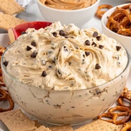 Bowl of buckeye chocolate chip dip surrounded by pretzels and graham crackers, ready for serving.