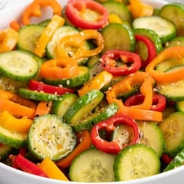 Bowl of cucumber and bell pepper salad with red, orange, and yellow peppers