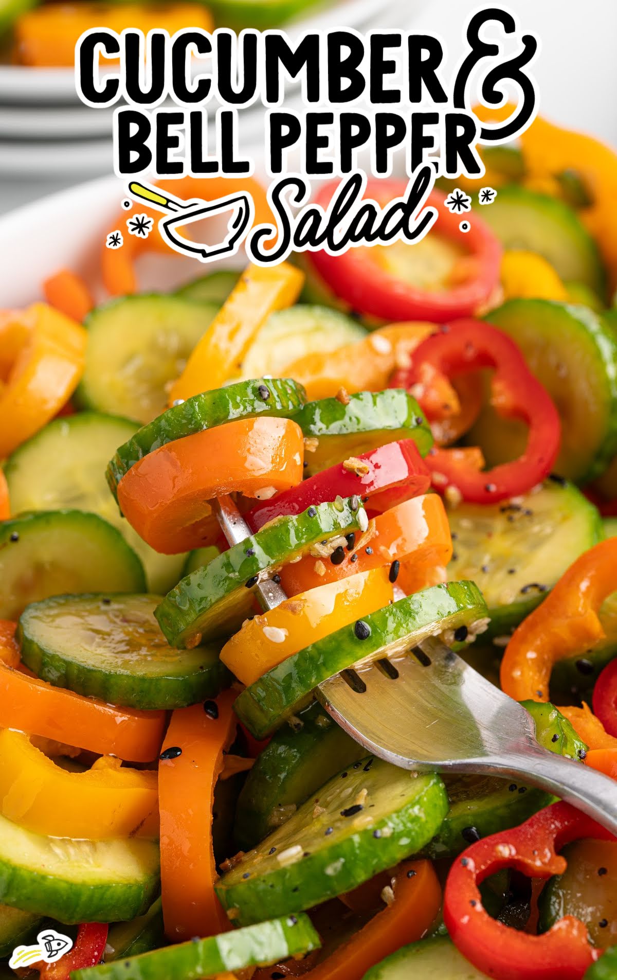 Fork lifting cucumber and bell pepper slices from salad bowl