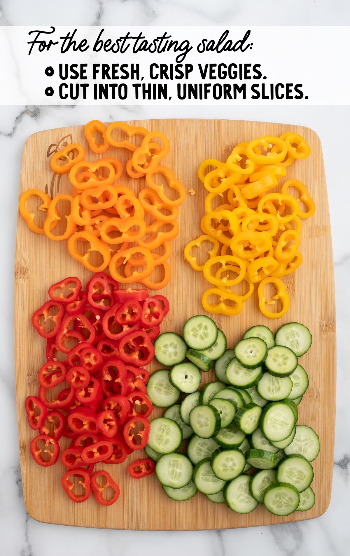 Sliced cucumbers and red, orange, and yellow bell peppers arranged on a cutting board