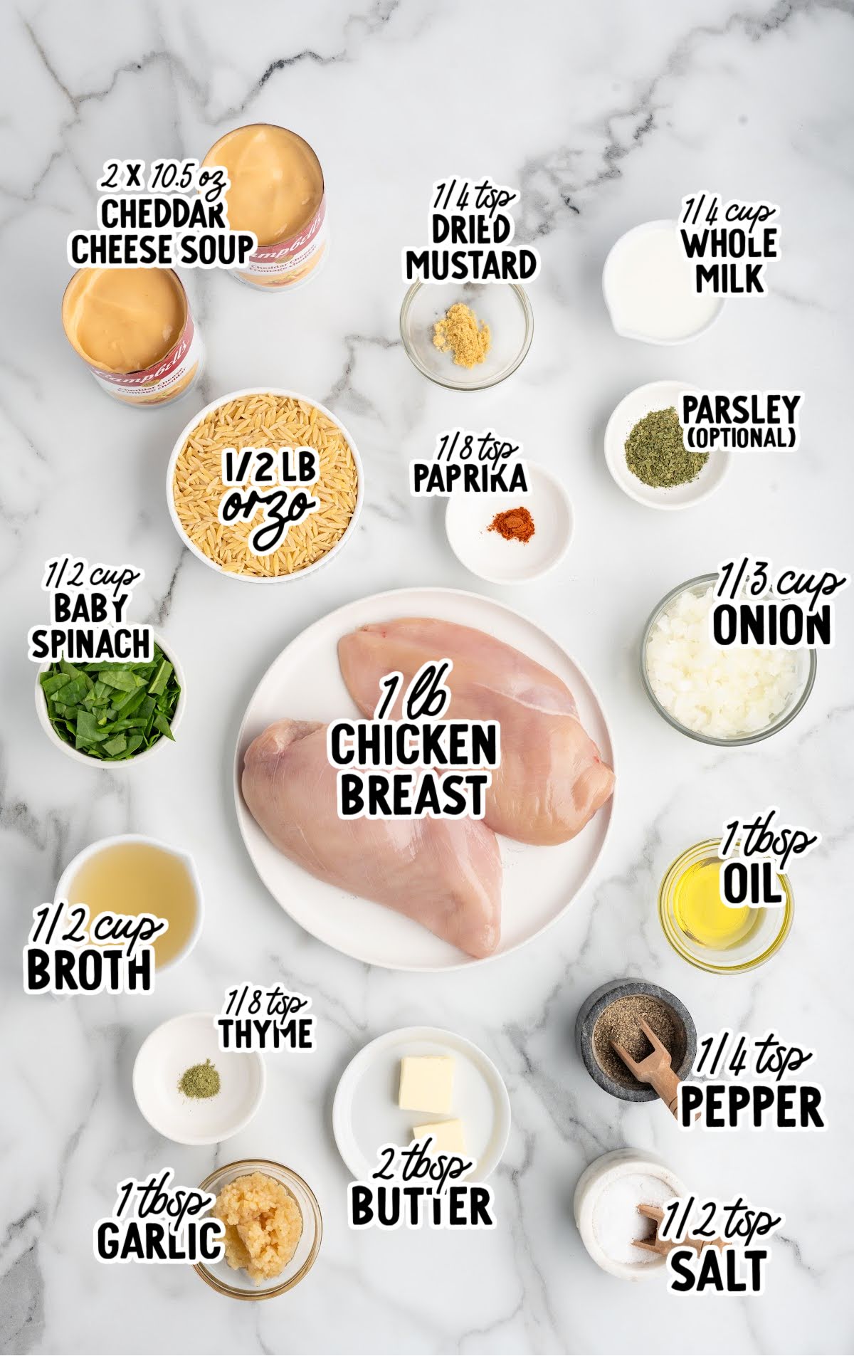 Flat lay of cheesy chicken orzo ingredients including chicken, orzo, cheddar cheese soup, spinach, and spices