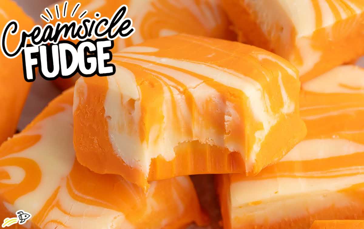 Stacked orange creamsicle fudge squares with distinct white vanilla swirls