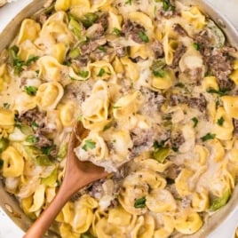 Close-up of cheesy Philly cheesesteak tortellini pasta with steak strips and green peppers in a creamy sauce