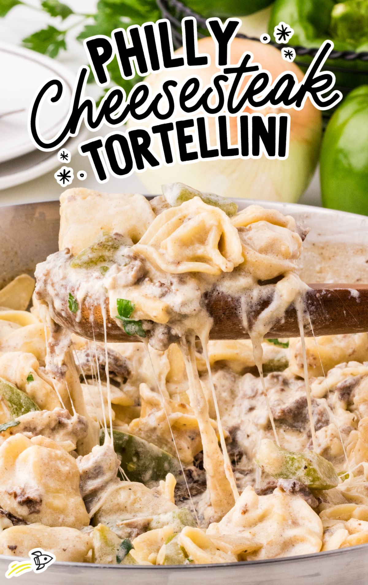 Pan of Philly cheesesteak tortellini with melty mozzarella cheese and tender steak pieces mixed with bell peppers