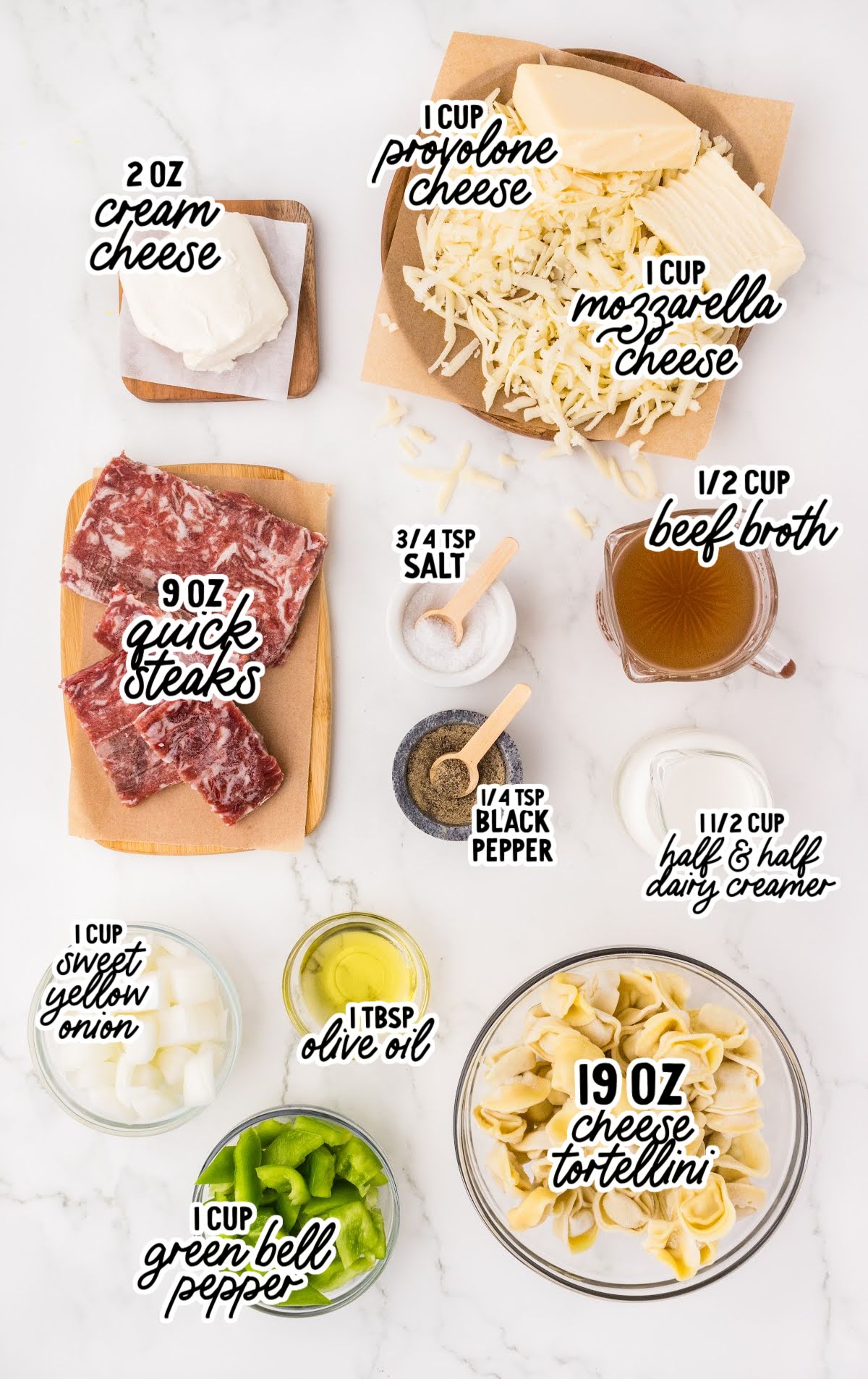 Flat lay of Philly cheesesteak tortellini ingredients including quick steaks, tortellini, cream cheese, and green bell peppers