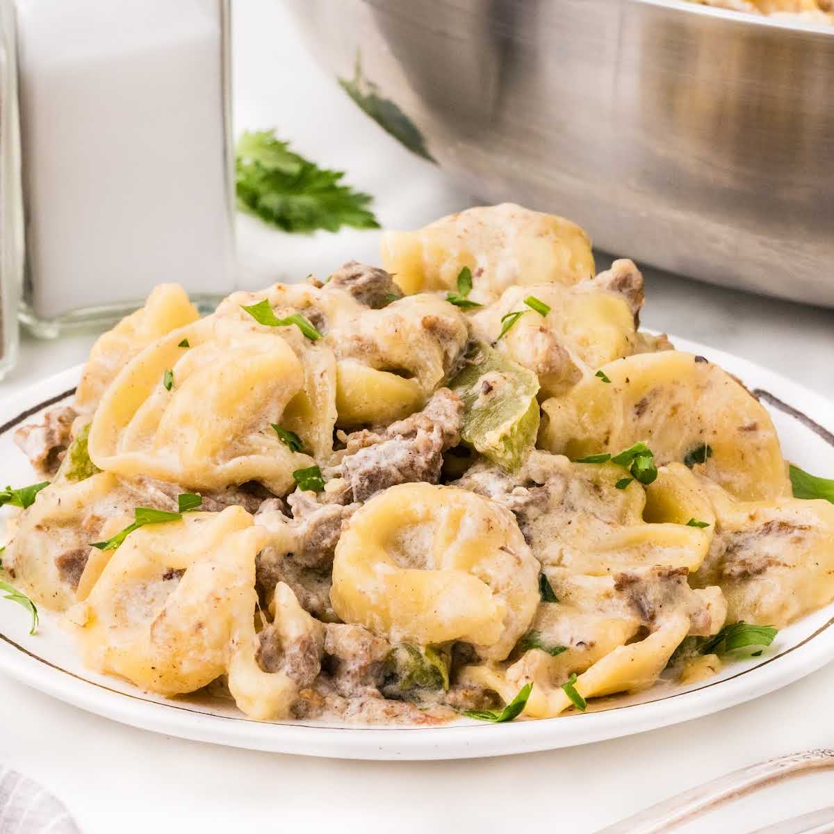 Cheesy steak tortellini with bell peppers and creamy sauce cooked together in one pan