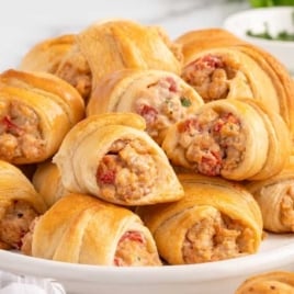 Close-up of baked Rotel sausage and cream cheese crescents showing the creamy sausage and tomato filling inside the flaky pastry.