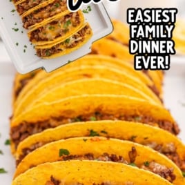 Easy baked tacos lined up on a tray, topped with cheese and beef, captioned as the easiest family dinner ever.