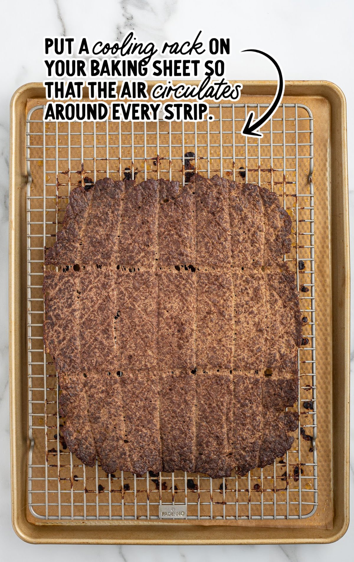 Cooked beef jerky strips on a cooling rack for even air circulation.