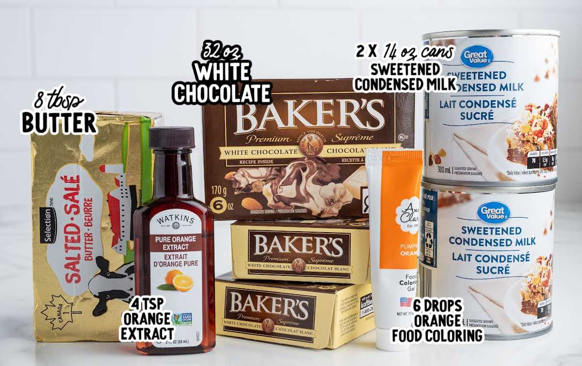 Ingredients for orange creamsicle fudge including white chocolate, sweetened condensed milk, butter, orange extract, and food coloring