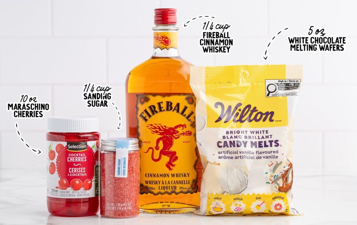Labeled ingredients for Fireball cherry bombs including Fireball whiskey, maraschino cherries, red sanding sugar, and white candy melts.