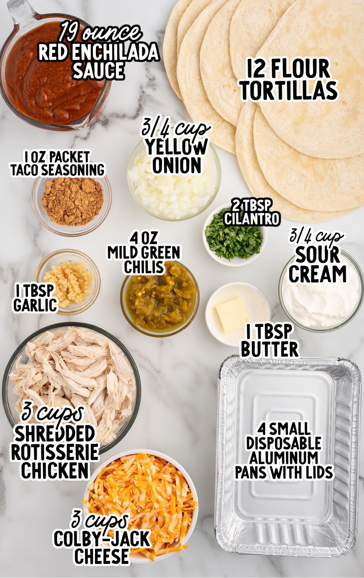 Overhead view of labeled ingredients for freezer enchiladas including tortillas, enchilada sauce, shredded chicken, cheese, onions, sour cream, and seasonings.