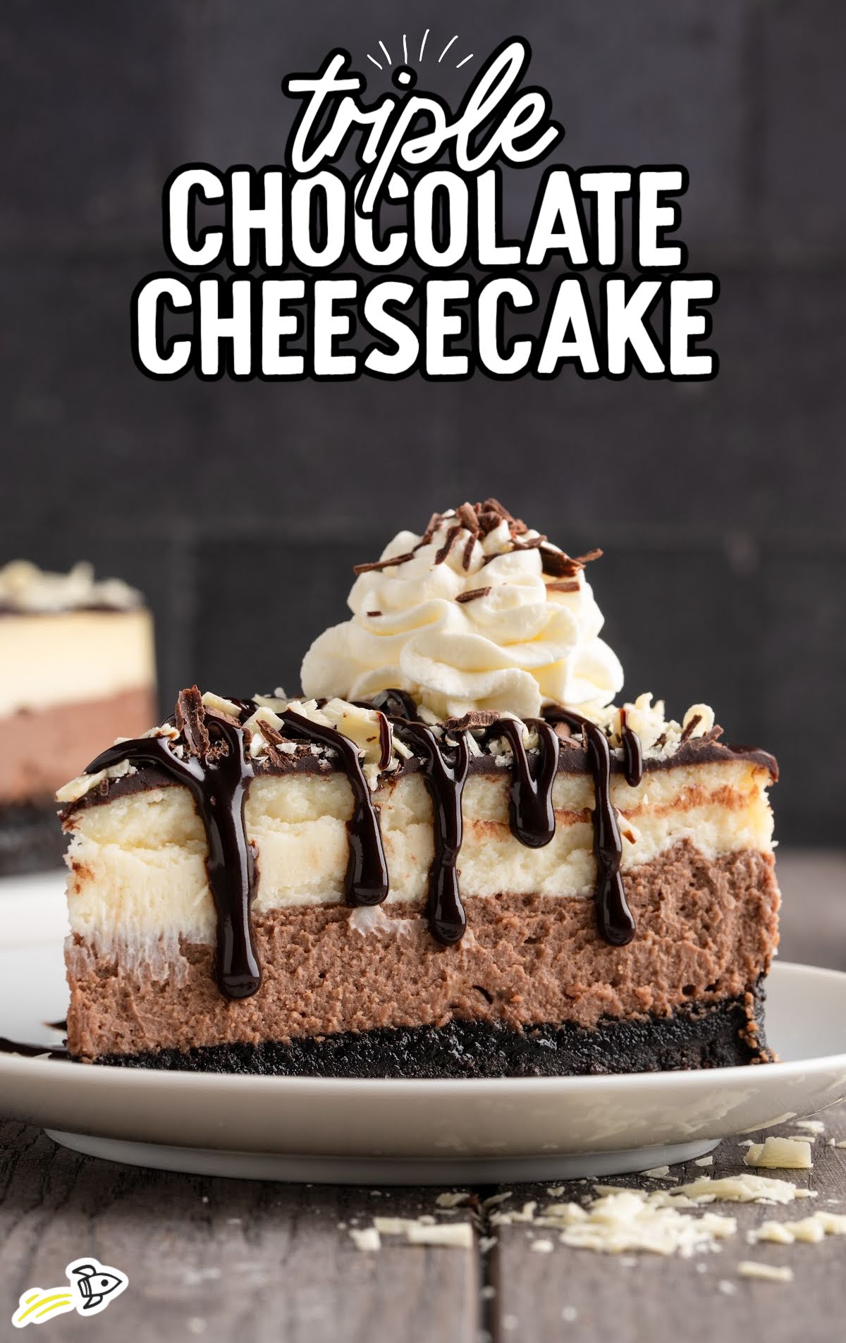 Slice of triple chocolate cheesecake topped with whipped cream, chocolate drizzle, and chocolate shavings on an Oreo crust.