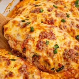 Close-up of baked ricotta chicken topped with melted cheese and fresh basil