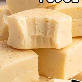 Close-up of creamy yellow eggnog fudge squares, some with small bites taken, sprinkled with nutmeg. Text reads Eggnog Fudge Recipe and Vintage Recipe!! with a black arrow pointing to the text.