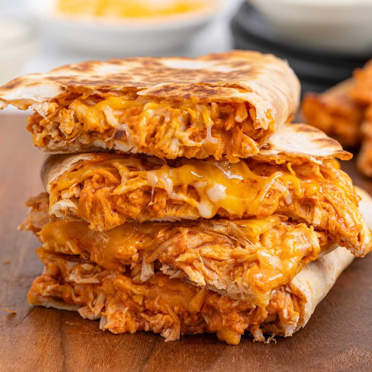 Cooked buffalo chicken quesadillas browning in a skillet until golden