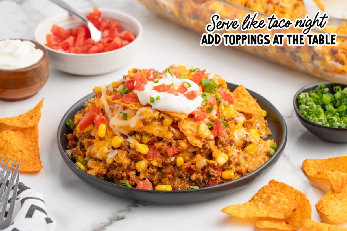 Finished Doritos taco casserole topped with crushed Doritos and melted cheese in a glass baking dish