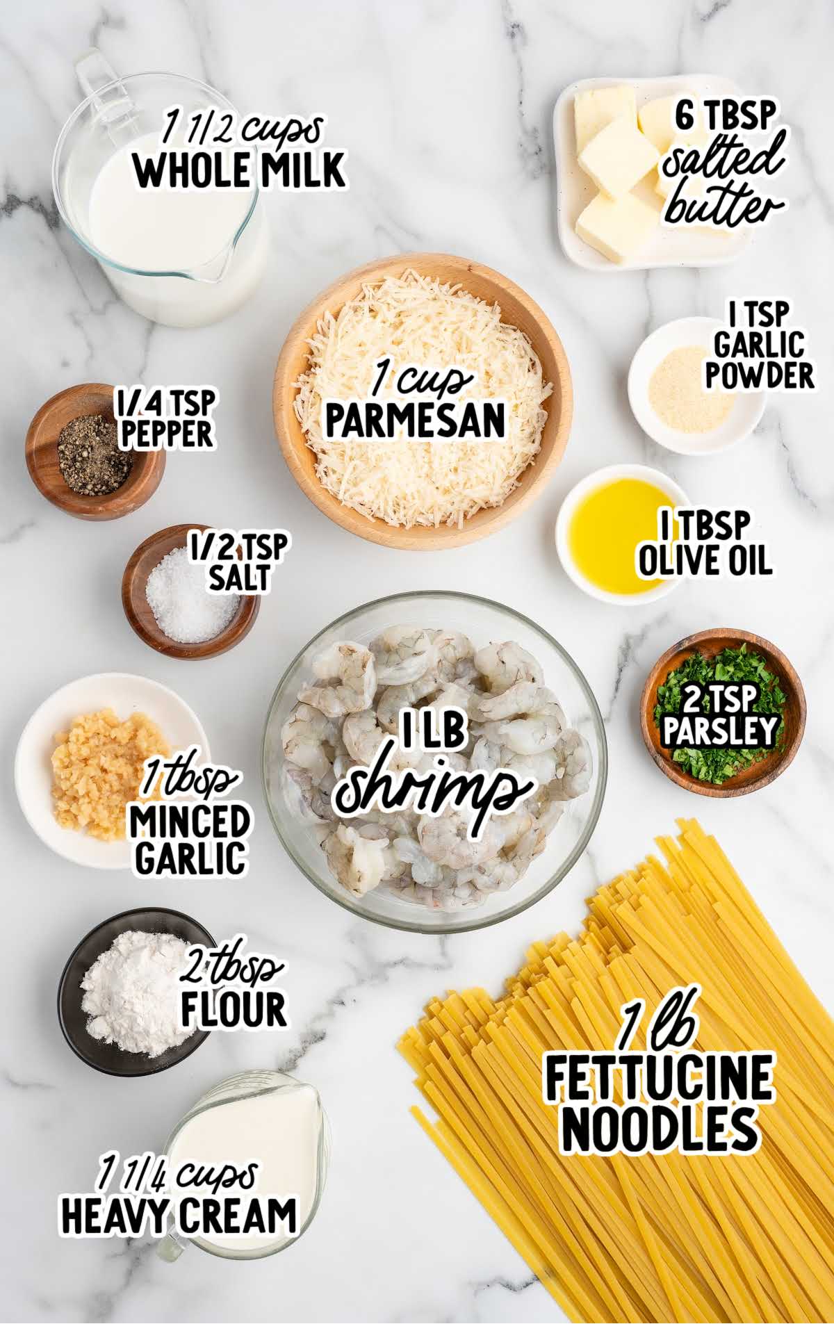 Ingredients for shrimp alfredo pasta including shrimp, fettuccine, parmesan, cream, and butter