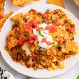 Cheesy Doritos taco casserole baked in a glass dish with ground beef, corn, and melted cheese