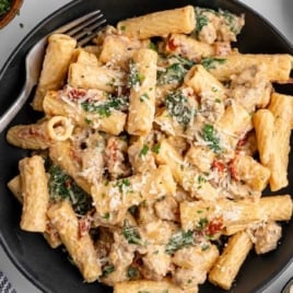 a bowl of creamy Italian sausage pasta with a fork