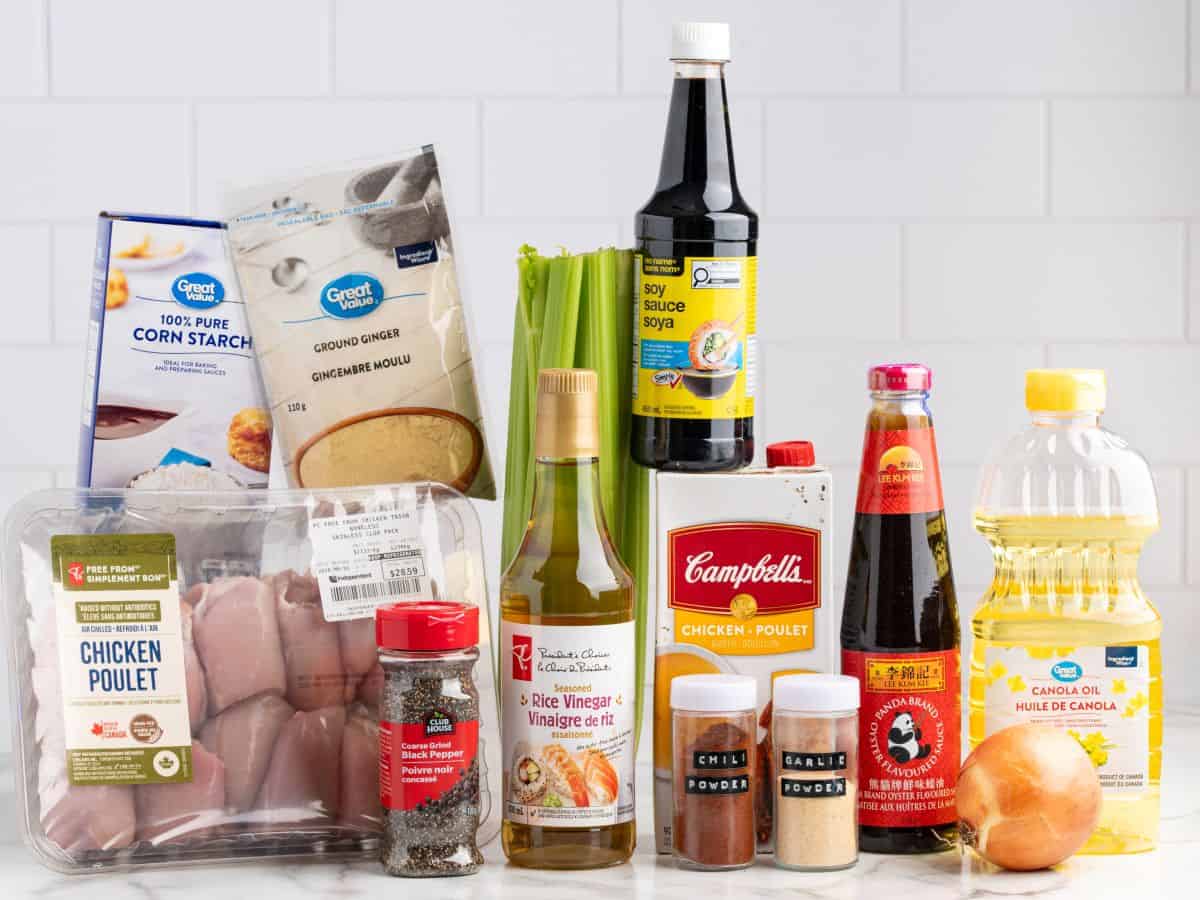 A variety of cooking ingredients on a counter, including chicken thighs, celery, cornstarch, soy sauce, and spicesโeverything you need to prepare a homemade version of Panda Express Pepper Chicken.